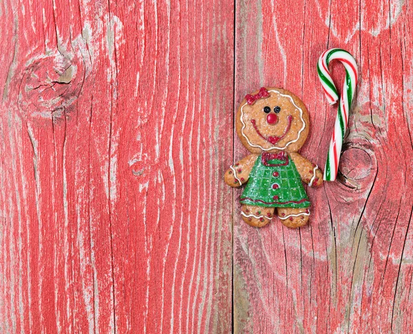 Gingerbread cookie and candy cane on rustic red wooden boards — Stock Photo, Image