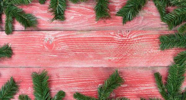 Tavole di legno rosso rustico con bordo ramo di abete natalizio — Foto Stock