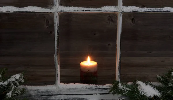 Snöiga fönster och fir grenar med glödande ljus — Stockfoto