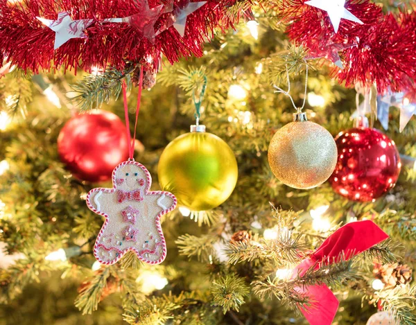 Holiday cookie hanging from fully decorated Christmas tree — Stock Photo, Image