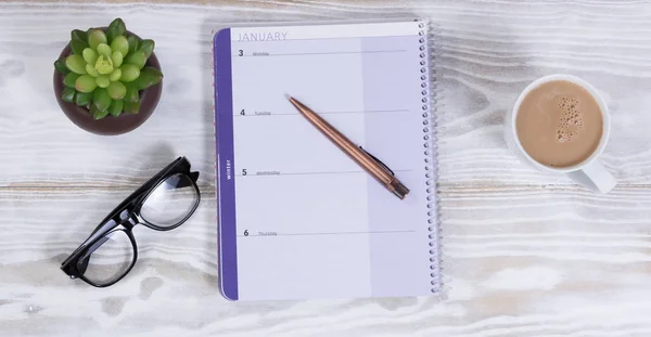Escritorio blanco con calendario y pluma más café — Foto de Stock
