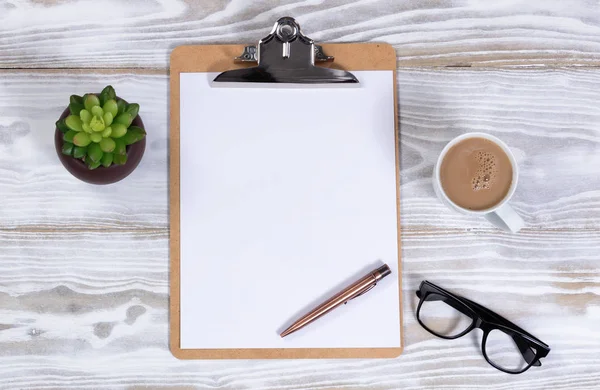 Weißer Schreibtisch mit leerem Klemmbrett und Papier plus Kaffee — Stockfoto