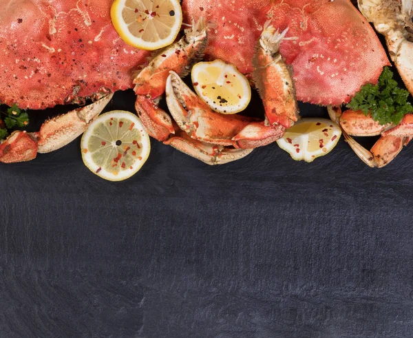 Crabe fraîchement cuit avec des épices sur pierre naturelle d'ardoise sombre — Photo