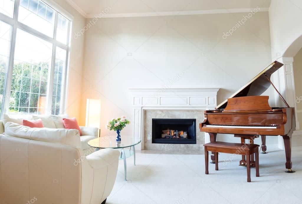 Living room decorated with leather sofa and piano with burning f