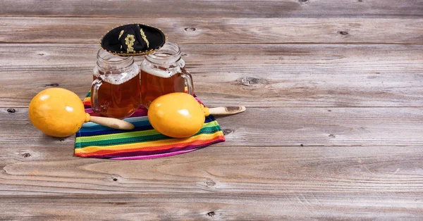 Cerveza con objetos de fiesta sobre mesa de madera rústica —  Fotos de Stock