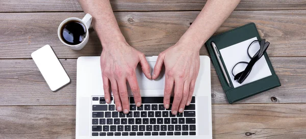 Visão superior do desktop de trabalho com as mãos no teclado do laptop com o — Fotografia de Stock