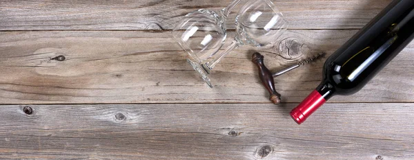 Unopen bottle of red wine and clean drinking glasses on rustic w — Stock Photo, Image