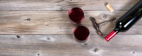 Unopen fles rode wijn met oude kurkentrekker en volledige drinken g — Stockfoto