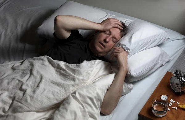 Mature man in physical pain while trying to fall asleep — Stock Photo, Image