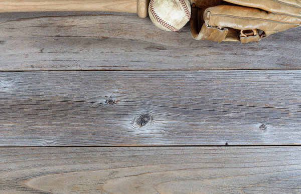Top border of used baseball equipment on rustic wooden boards