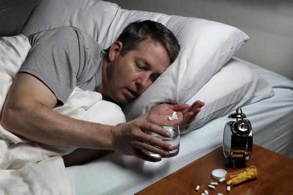Зрелый человек не может заснуть, готовясь принять лекарство. — стоковое фото