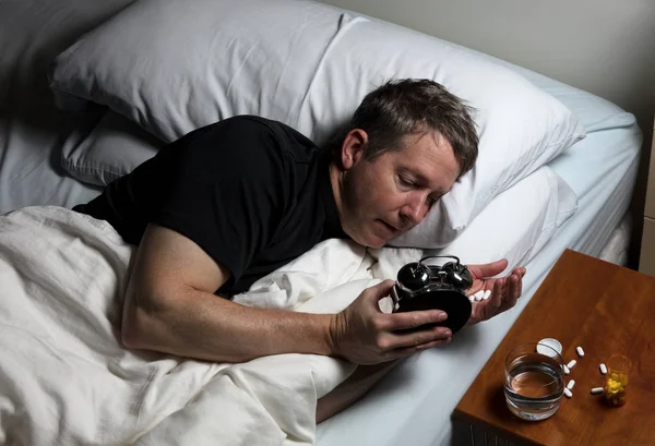 Mature man having difficulty falling asleep at night thus taking — Stock Photo, Image