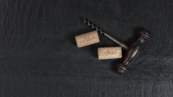 Overhead view of vintage corkscrew on black slate background — Stock Photo, Image