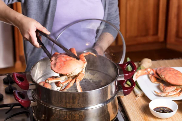 Hand removing cooked crab from steam pot — Stock Photo, Image
