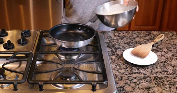 Наливая тесто в сковородку для горячих блинчиков — стоковое видео