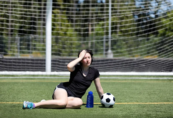 Teen girl feeling too hot on soccer field on hot day — Stock Photo, Image