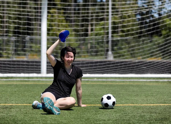 Teen girl pouring water on her head during a hot day on the socc — Stock Photo, Image