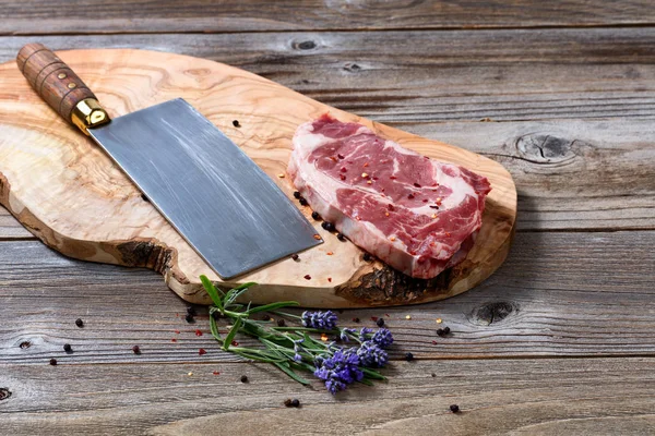Μεγάλο μαχαίρι κρεοπωλείου και ένα φρέσκο κομμένα καρυκευμένο βόειο κρέας έτοιμοι να co — Φωτογραφία Αρχείου