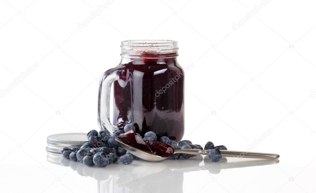 Fresh blueberry jam and berries with glass jar isolated on white