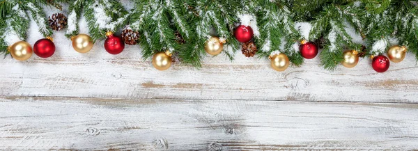 Kerst takken met gouden en rode versieringen met sneeuw op de ru — Stockfoto