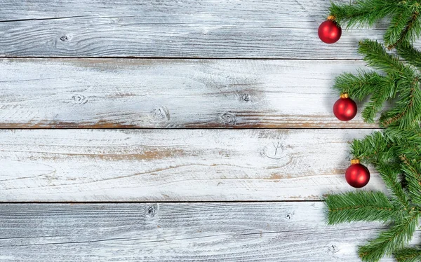 Natal galhos evergreen e ornamentos vermelhos no nó rústico — Fotografia de Stock