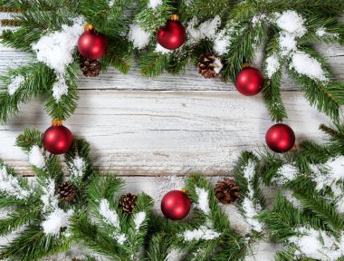 Dairesel sınır köknar üzerinde asılı karlı Noel kırmızı süsler 