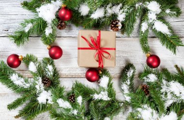 Köknar ağacı kepek üzerinde asılı karlı Noel kırmızı süsler ile hediye