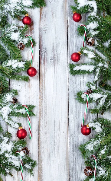 Verticale randen van besneeuwde rode Kerst ornamenten en riet van het suikergoed — Stockfoto