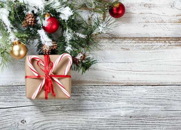 Caja de regalo envuelta en papel con bastones de caramelo para la temporada navideña — Foto de Stock