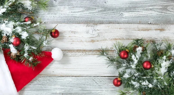 Снежная елка с шишками и шляпой Санта Клауса — стоковое фото