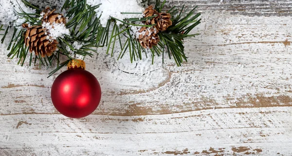 Vánoční červená ozdoba visí z větve stromu zasněžené hrubé jedle — Stock fotografie