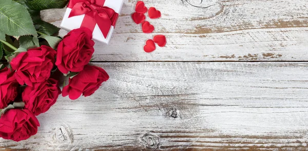Κουτί δώρου με κόκκινα τριαντάφυλλα και καρδιές σε ρουστίκ ξύλο — Φωτογραφία Αρχείου