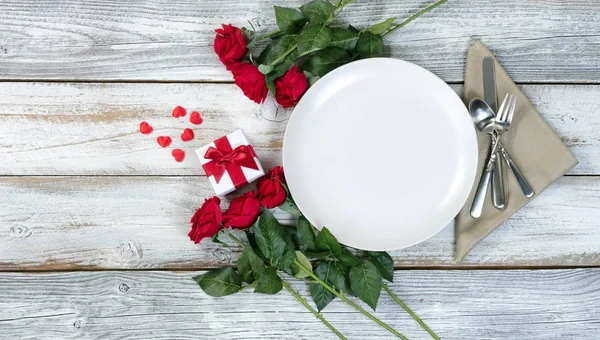 Alla hjärtans middag miljö med blommor och present på vitt bord — Stockfoto
