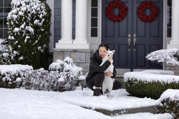 Зрілі жінки і її сімейний собака зовні в снігу — стокове фото