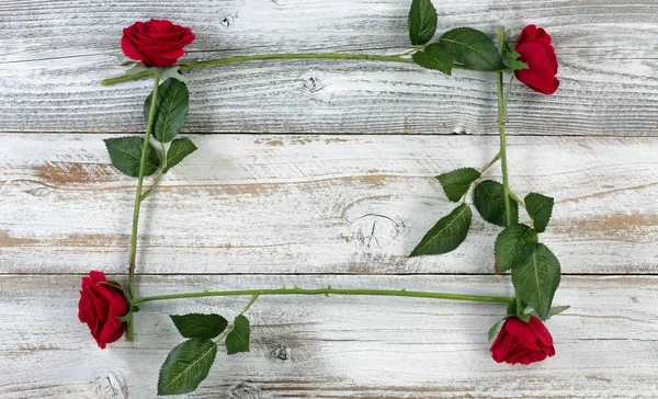 Esquema cuadrado de rosas rojas sobre fondo blanco rústico de madera —  Fotos de Stock