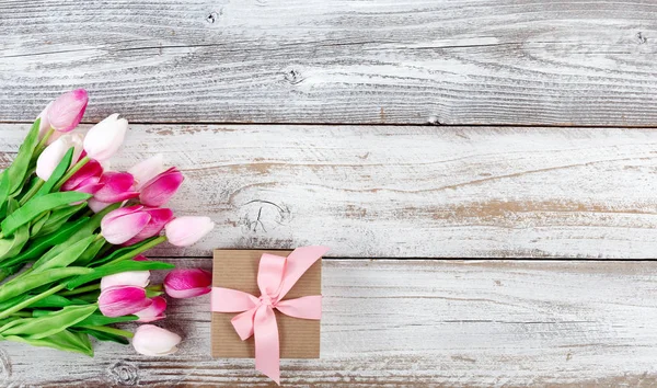 Springtime pink tulips and gift box on white rustic wooden board — Stock Photo, Image