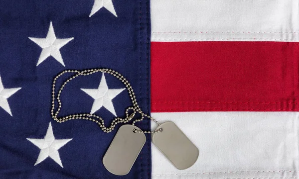 Cloth United States flag with military ID tags in overhead view — Stock Photo, Image