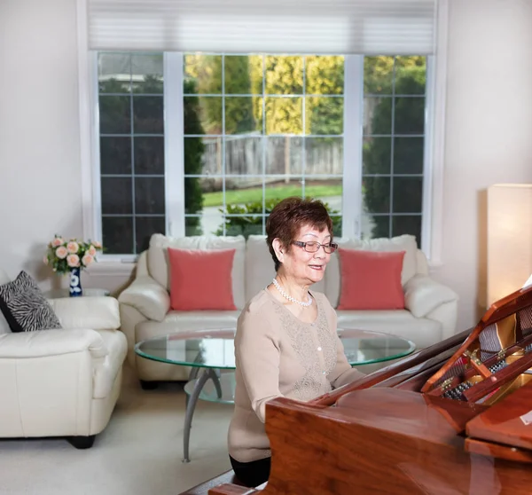 资深妇女演奏她的钢琴与幸福 — 图库照片