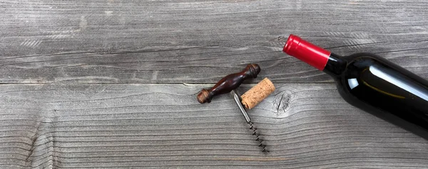 Donkere fles rode wijn met vintage corkscrew op rustieke houten — Stockfoto