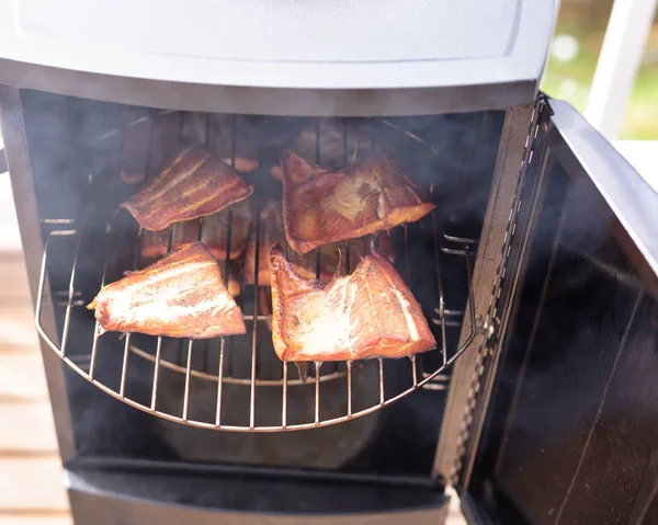 Open smoker with fresh fillet of salmon being cooked in close up — Stock Photo, Image