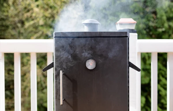 Close up of a smoker with fresh smoke coming out of barbeque coo — Stock Photo, Image