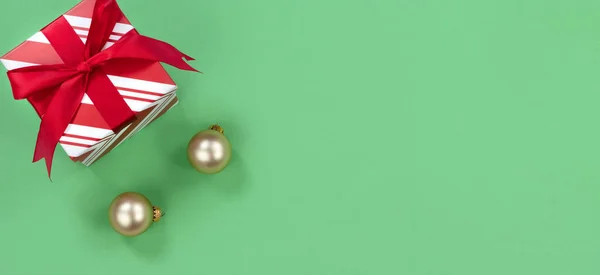 Luminoso sfondo verde con scatola regalo e ornamenti d'oro per t — Foto Stock