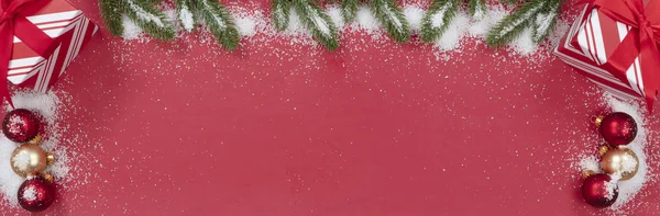 明亮的红色背景上挂满了雪的圣诞装饰 — 图库照片