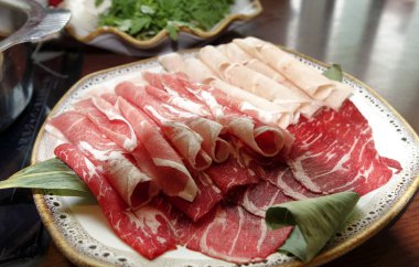 Pişirmek için ince dilimlenmiş çiğ et ve sıcak tencere.