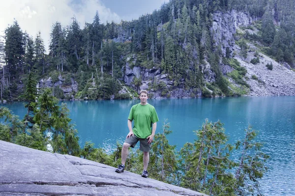 Человек, путешествующий в лесу возле живописного ледникового озера — стоковое фото