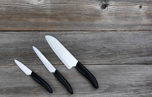 Set di coltelli in ceramica su tavole di legno rustico — Foto Stock