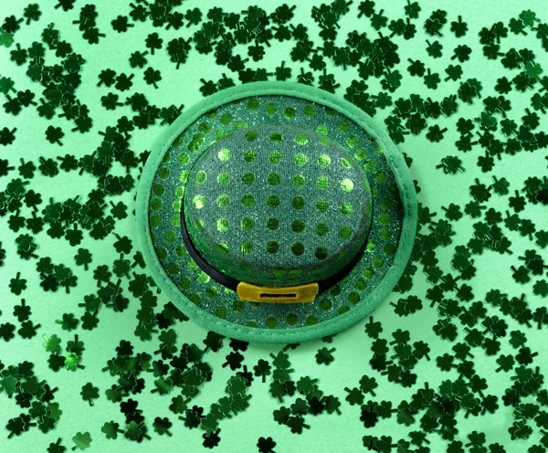 St Patricks Day with shamrocks and shiny hat on green background — Stock fotografie