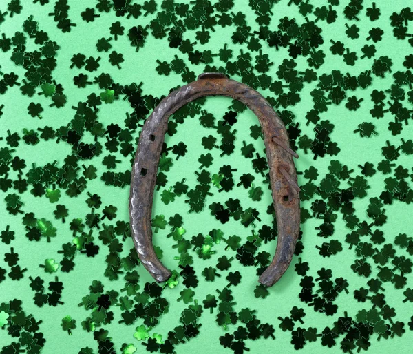 St Patricks Day with shamrocks and rusty horseshoe on green back — Stok fotoğraf