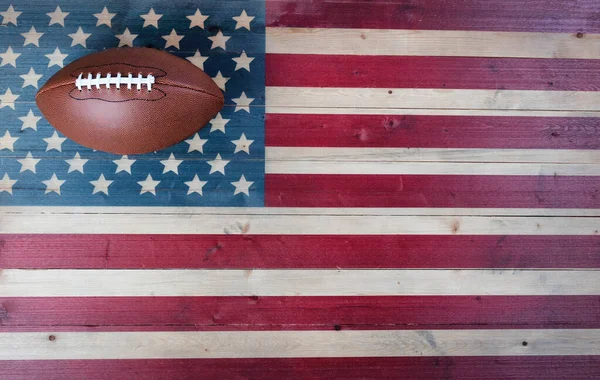 American football equipment on vintage wooden US flag background. USA sports concept with copy space