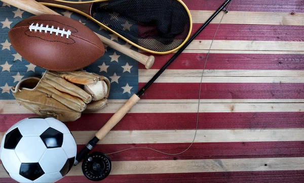 足球和钓鱼用的各种运动器材 用老式木制美国国旗制作 — 图库照片